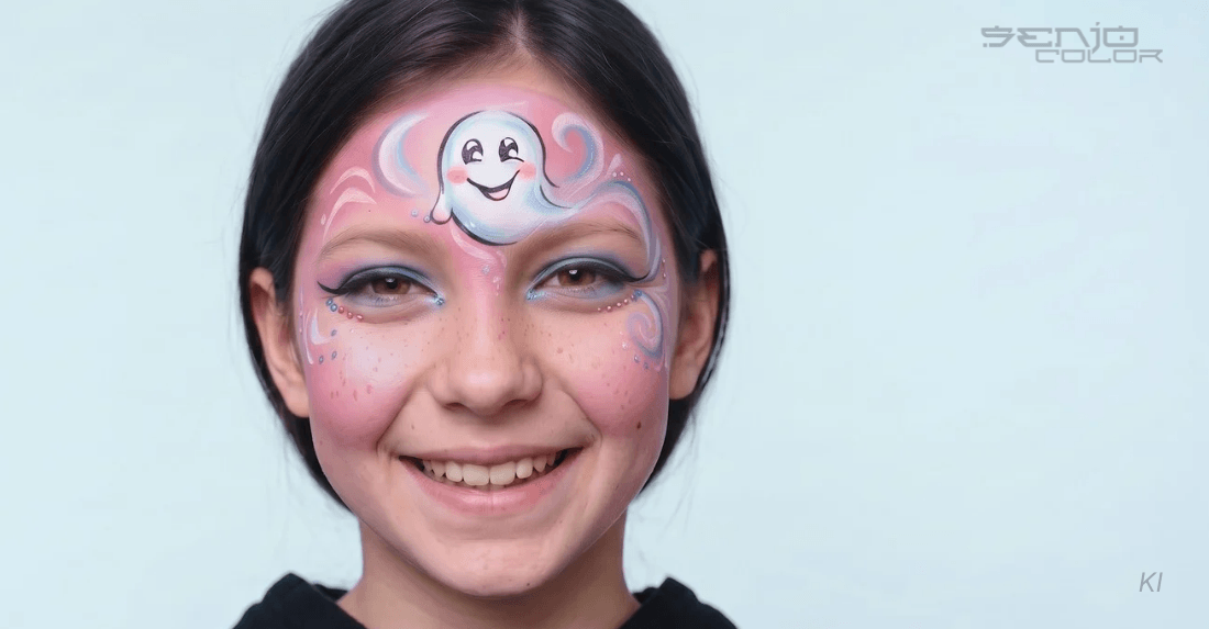 Mädchen mit Kinderschminke Motiv Geist auf der Stirn rosa Grundierung und Schnörkel zur Verzierung