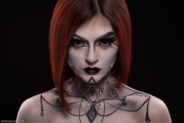 Frau mit roten Haaren im Schwarz-Weißen-Gothic-Makeup
