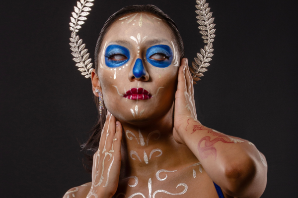 Frau mit Sugar Skull Makeup mit blauen Augen und weißen Verzierungen von Alexander Ojodelince