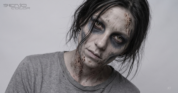 Frau mit Zombie-Make-up: Weiße Grundierung und grau-schwarze Schattierungen 