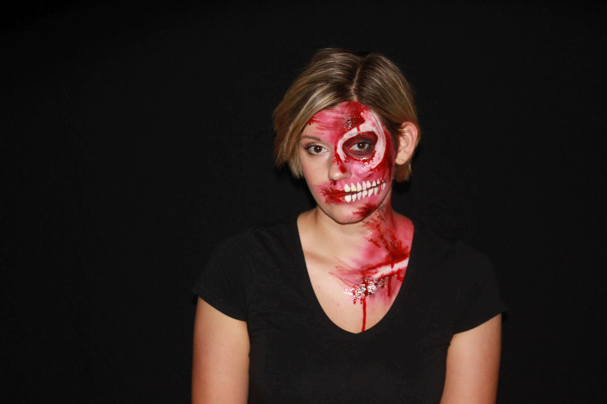Blutiges Halloween-Make-up auf einer Gesichtshälfte und Dekolleté